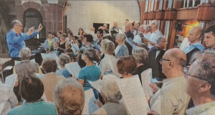 Foto von Bruno Hamm mit seinen Chören auf der Orgelempore von Herz Jesu